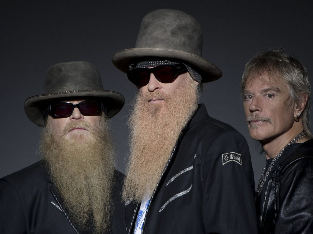Le trio ZZ Top : Billy Gibbons et Dusty Hill avec leurs barbes emblématiques, aux côtés de Frank Beard, seul membre du groupe sans barbe