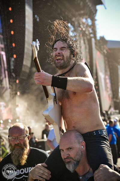 Joel O'Keeffe of Airbourne carried on a security guard's shoulders while soloing through the crowd at Wacken Open Air 2026.