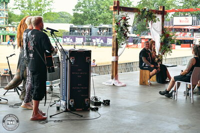 The newlyweds standing on the mainstage during their wedding at Wacken Open Air 2026.