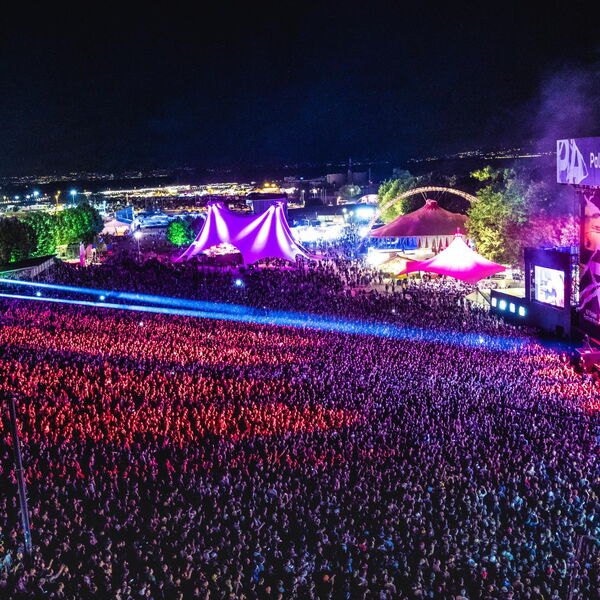Photographie du Paléo Festival montrant une scène en plein concert avec un public dense et des conditions de production professionnelles, illustrant l’organisation structurée de l’accueil presse et des zones dédiées aux photographes accrédités.
