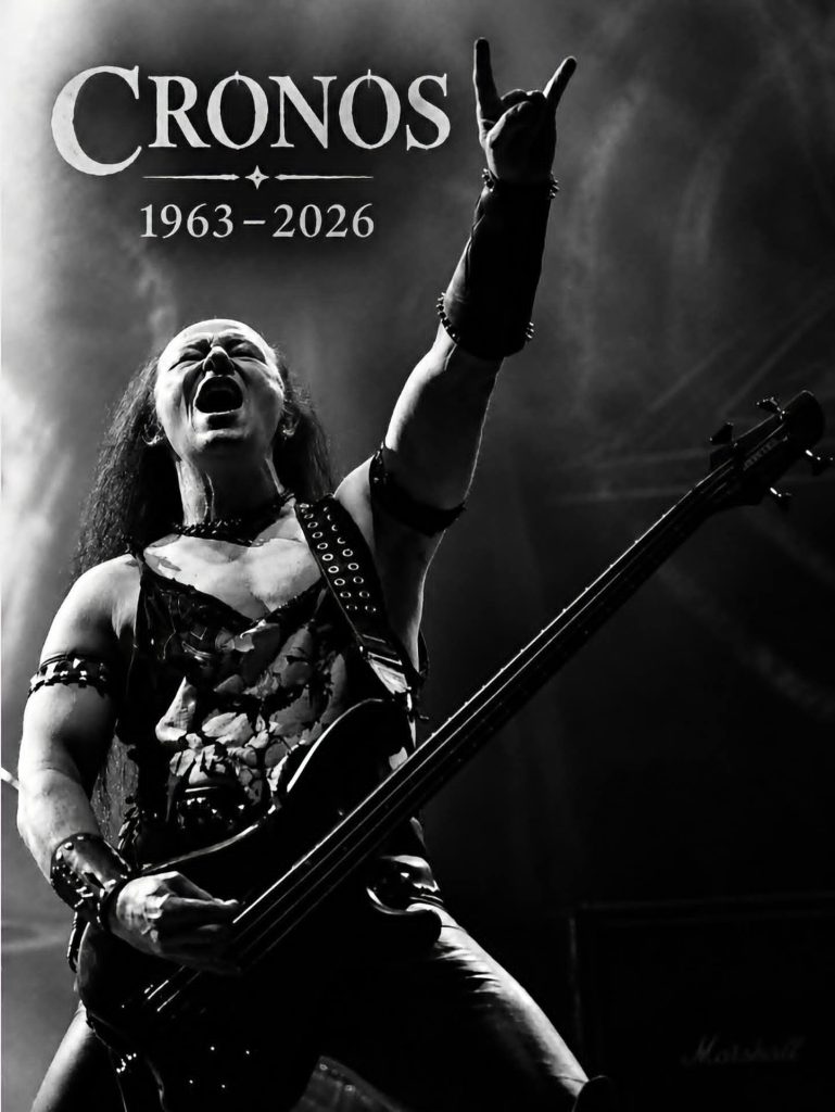Photo noir et blanc de Cronos, chanteur et bassiste de Venom, sur scène, avec la mention "1963-2026" en hommage au musicien disparu